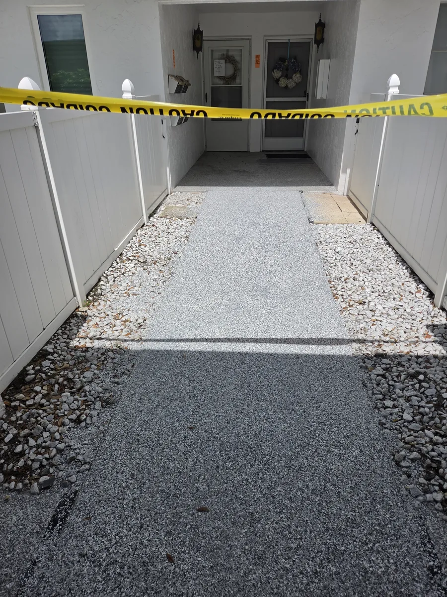 Full-broadcast gray flake coating on a condo entry walkway installed by Apex Epoxy Coatings